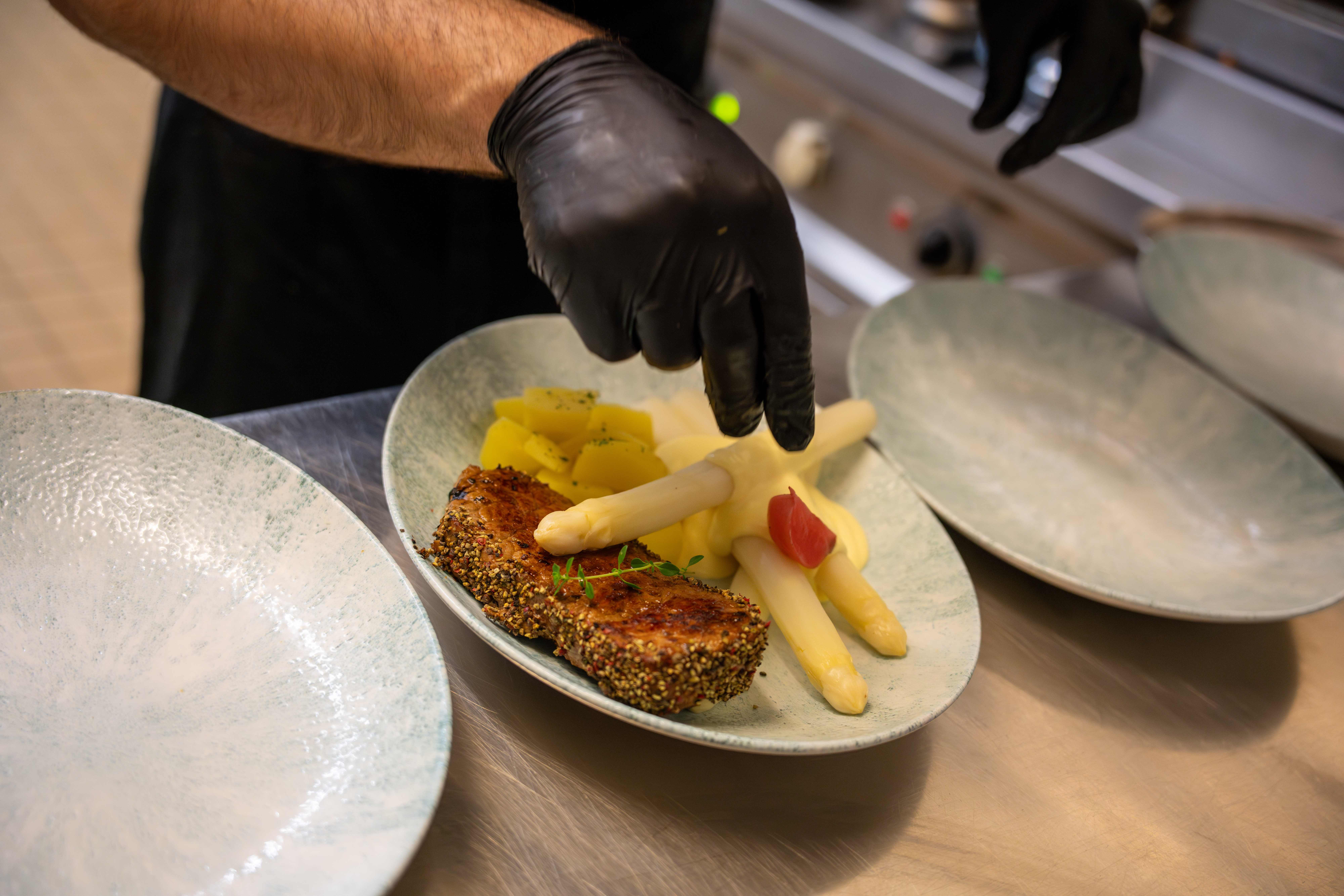 Professionelle Küchenarbeit - Gourmet-Gericht wird kunstvoll angerichtet